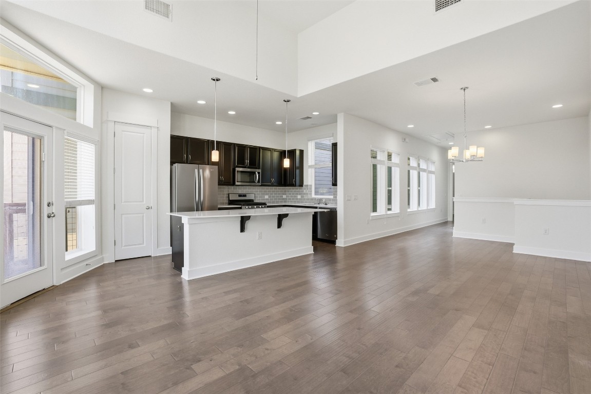 12604 Red Sparrow Street, Unit 14 Austin, TX 78729 - Photo 19 of 40 Unfurnished living room with recessed lighting, dark wood-style flooring, and a chandelier