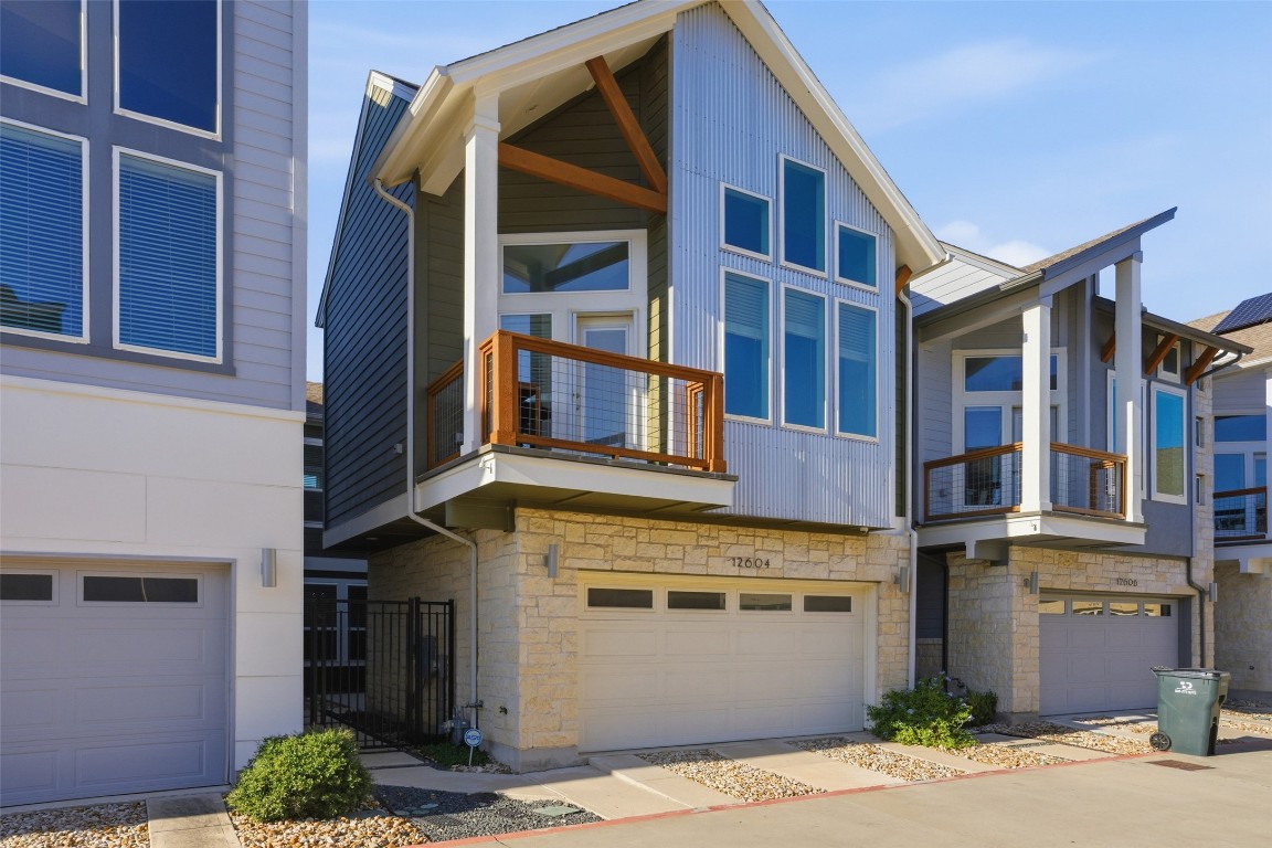 12604 Red Sparrow Street, Unit 14 Austin, TX 78729 - Photo 2 of 40 View of front of house featuring stone siding, a balcony, and an attached garage