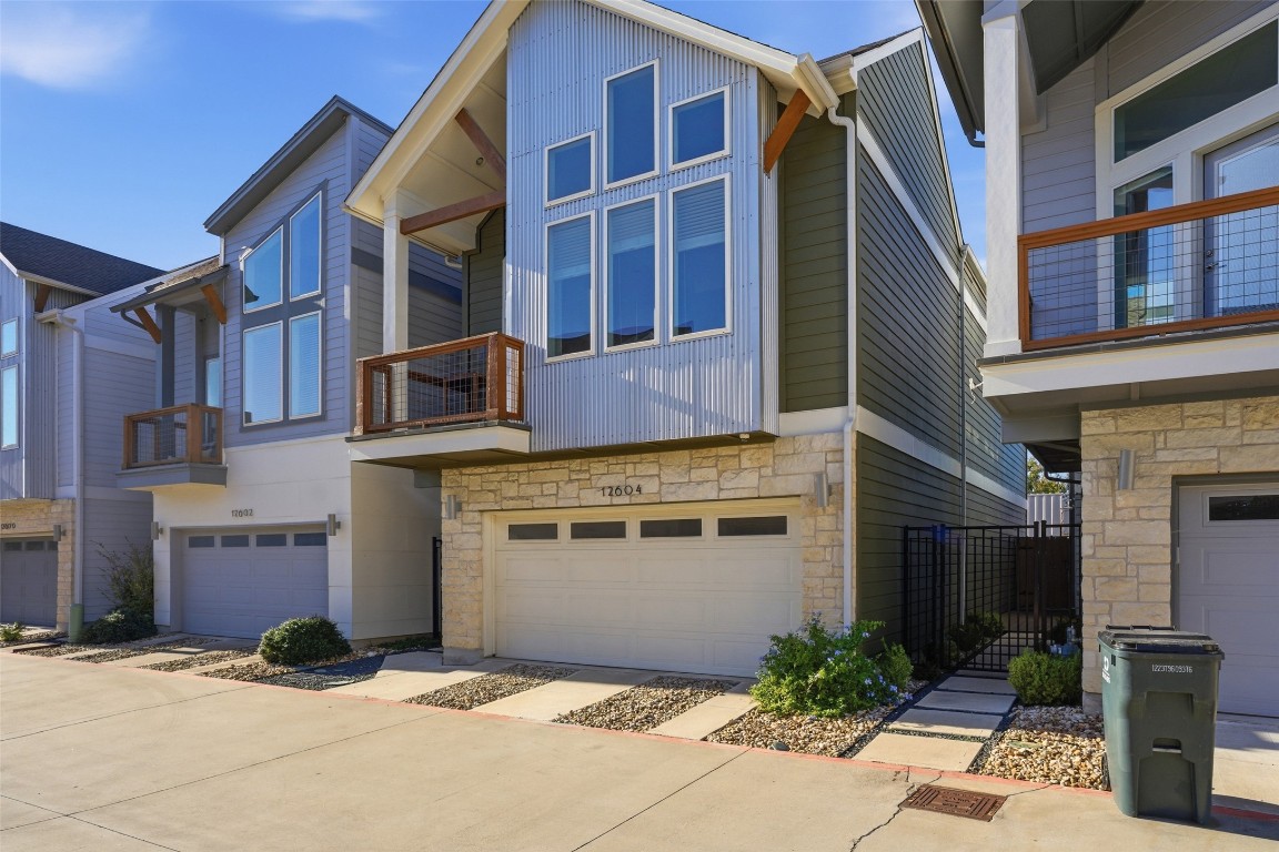 12604 Red Sparrow Street, Unit 14 Austin, TX 78729 - Photo 39 of 40 View of front of property with a balcony, stone siding, and an attached garage
