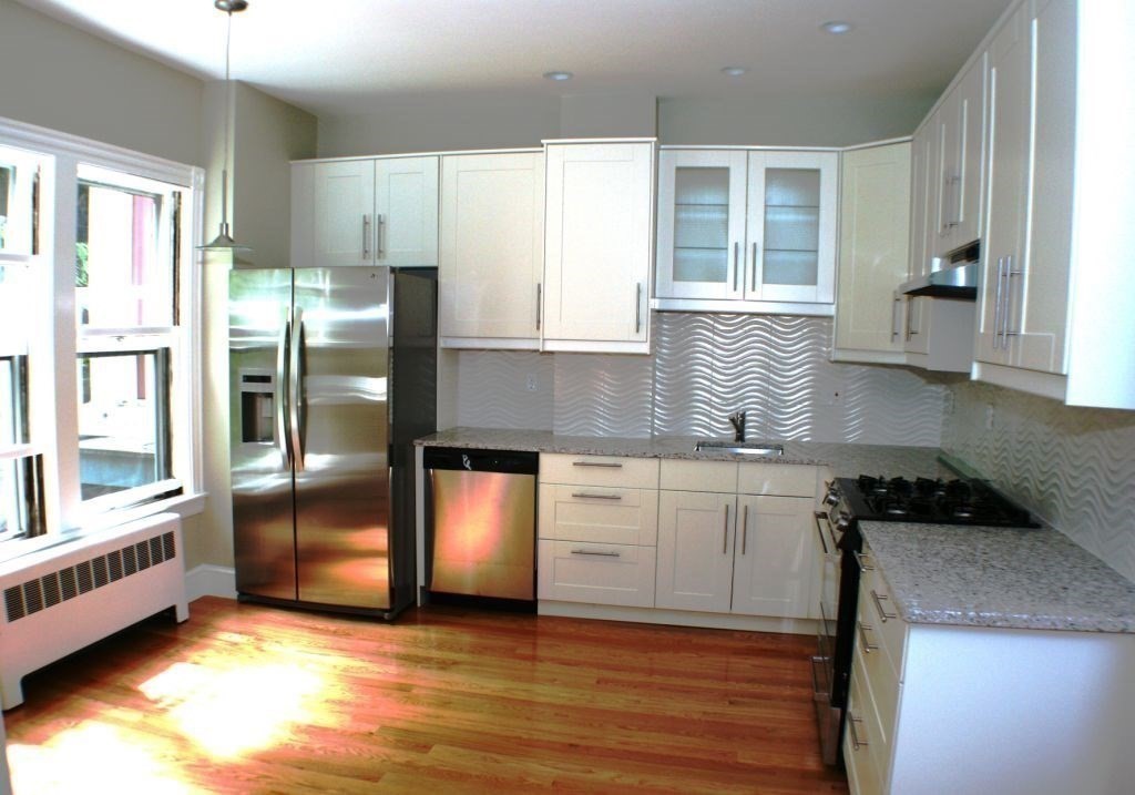 a kitchen with stainless steel appliances granite countertop a refrigerator and a stove top oven