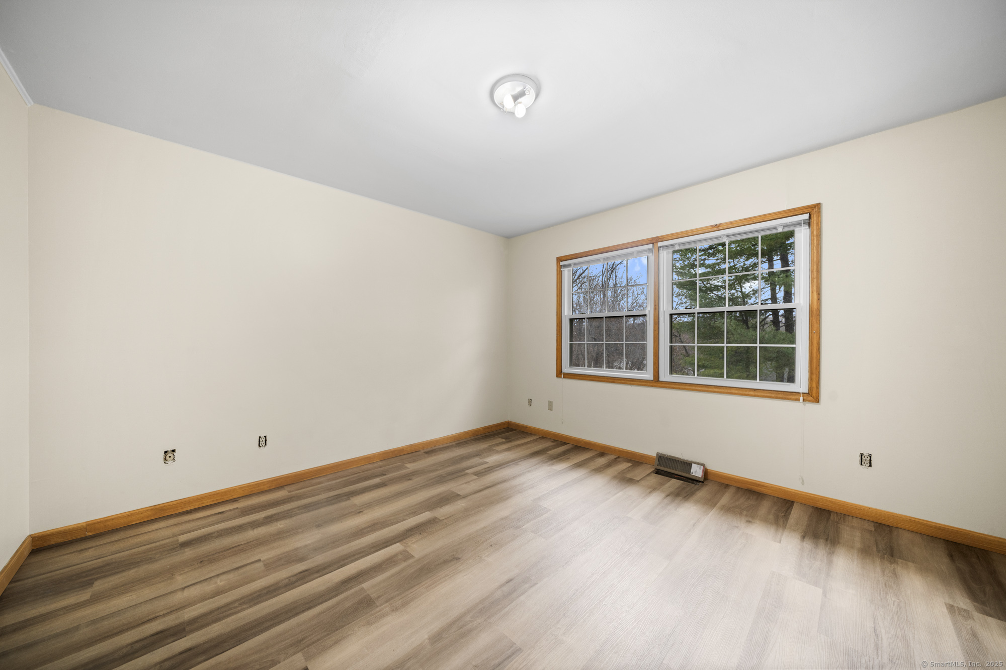 161 Kinney Street Torrington, CT 06790 - Photo 16 of 19 a view of an empty room with wooden floor and a window