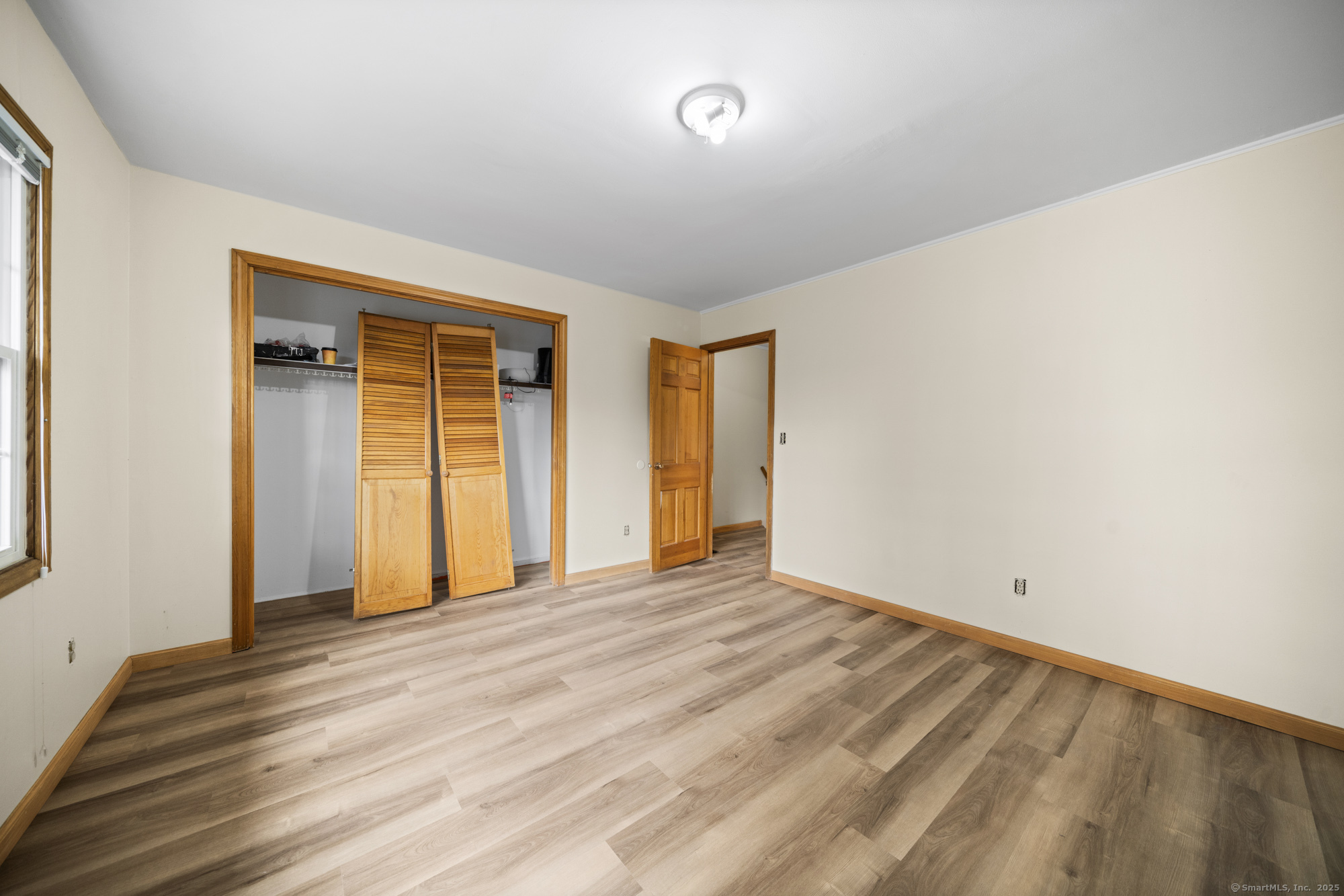 161 Kinney Street Torrington, CT 06790 - Photo 17 of 19 a view of an empty room with wooden floor and windows