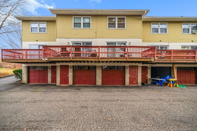 a view of a house with wooden deck and a barbeque