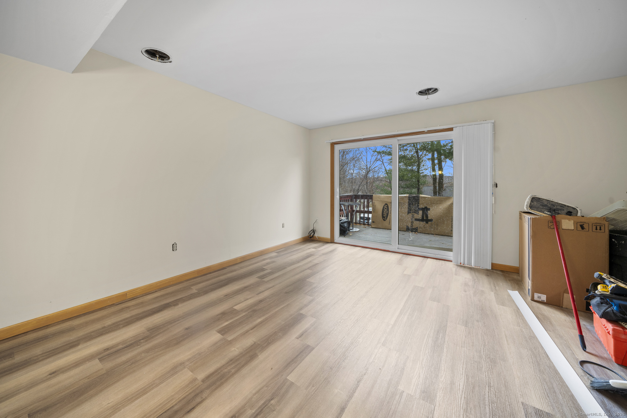 161 Kinney Street Torrington, CT 06790 - Photo 4 of 19 a view of an empty room with wooden floor and a window