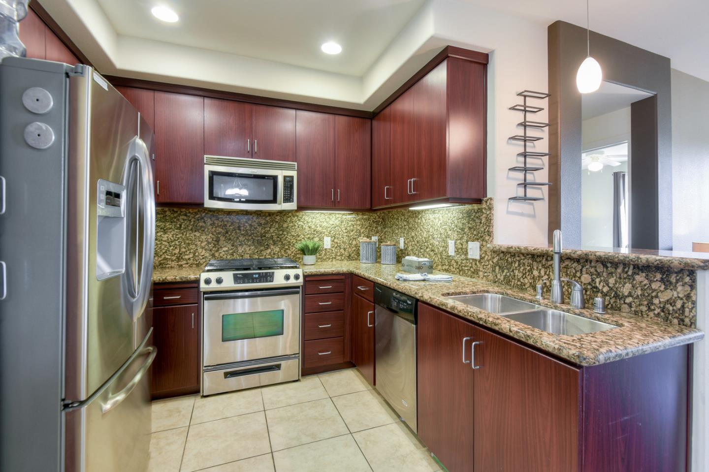 1101 South Main Street, Unit 316 Milpitas, CA 95035 - Photo 5 of 30 a kitchen with stainless steel appliances granite countertop wooden cabinets a sink and a stove