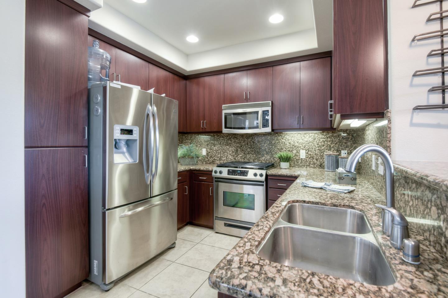 1101 South Main Street, Unit 316 Milpitas, CA 95035 - Photo 6 of 30 a kitchen with stainless steel appliances granite countertop a refrigerator sink and stove