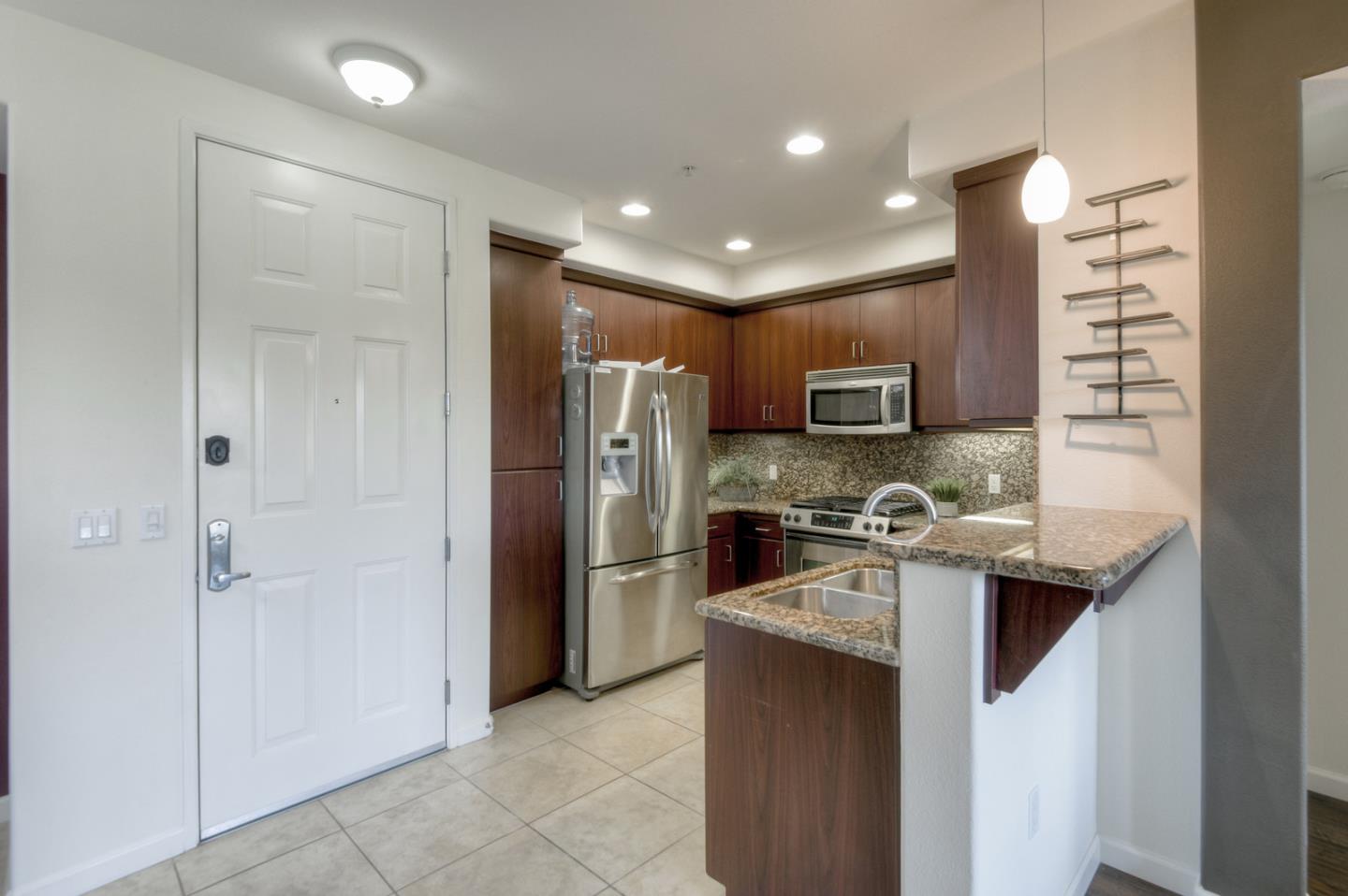1101 South Main Street, Unit 316 Milpitas, CA 95035 - Photo 9 of 30 a kitchen with kitchen island granite countertop stainless steel appliances and a sink
