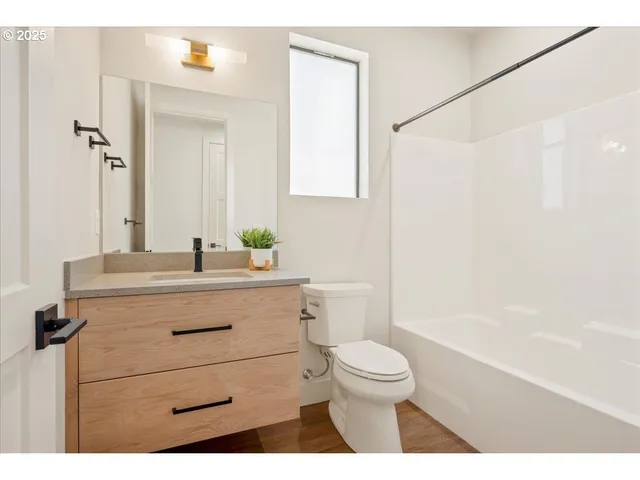 a utility room with a sink a vanity and wooden floor