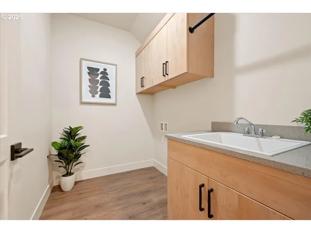 a view of a kitchen with a sink and dishwasher a refrigerator with wooden floor