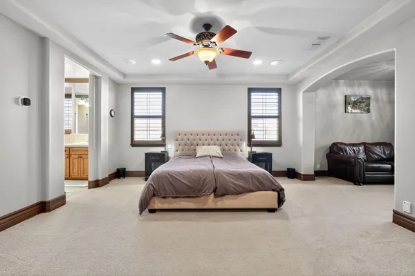 a spacious bedroom with a bed and ceiling fan