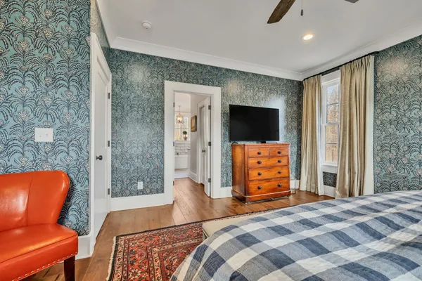a bedroom with a bed and a wooden floor