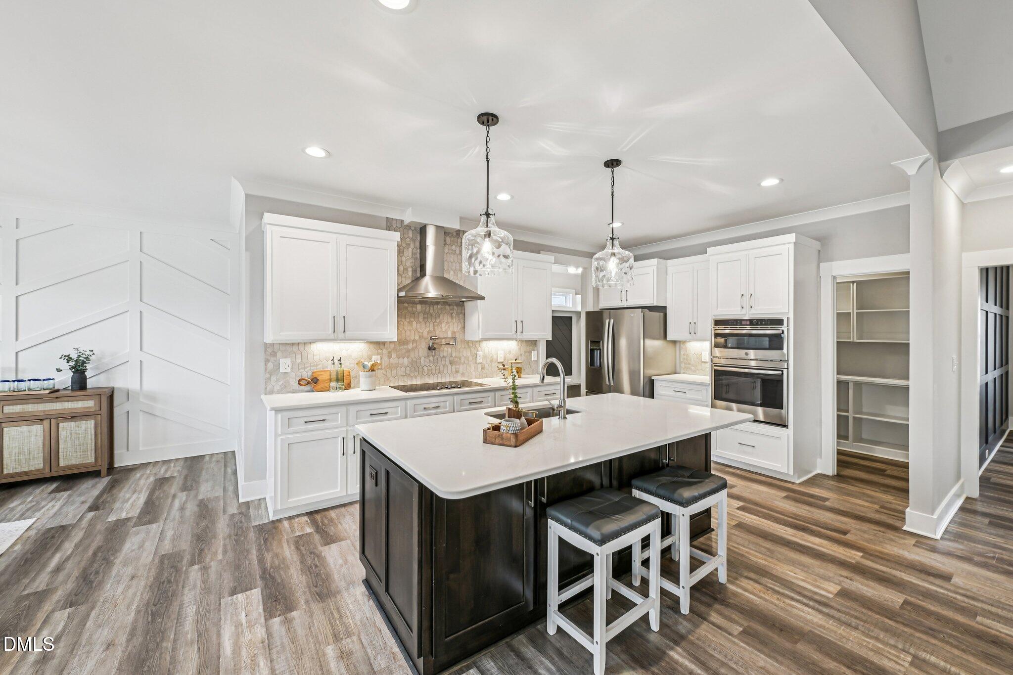 55 Dolores Court Willow Spring, NC 27592 - Photo 13 of 64 a kitchen with a table chairs refrigerator and cabinets