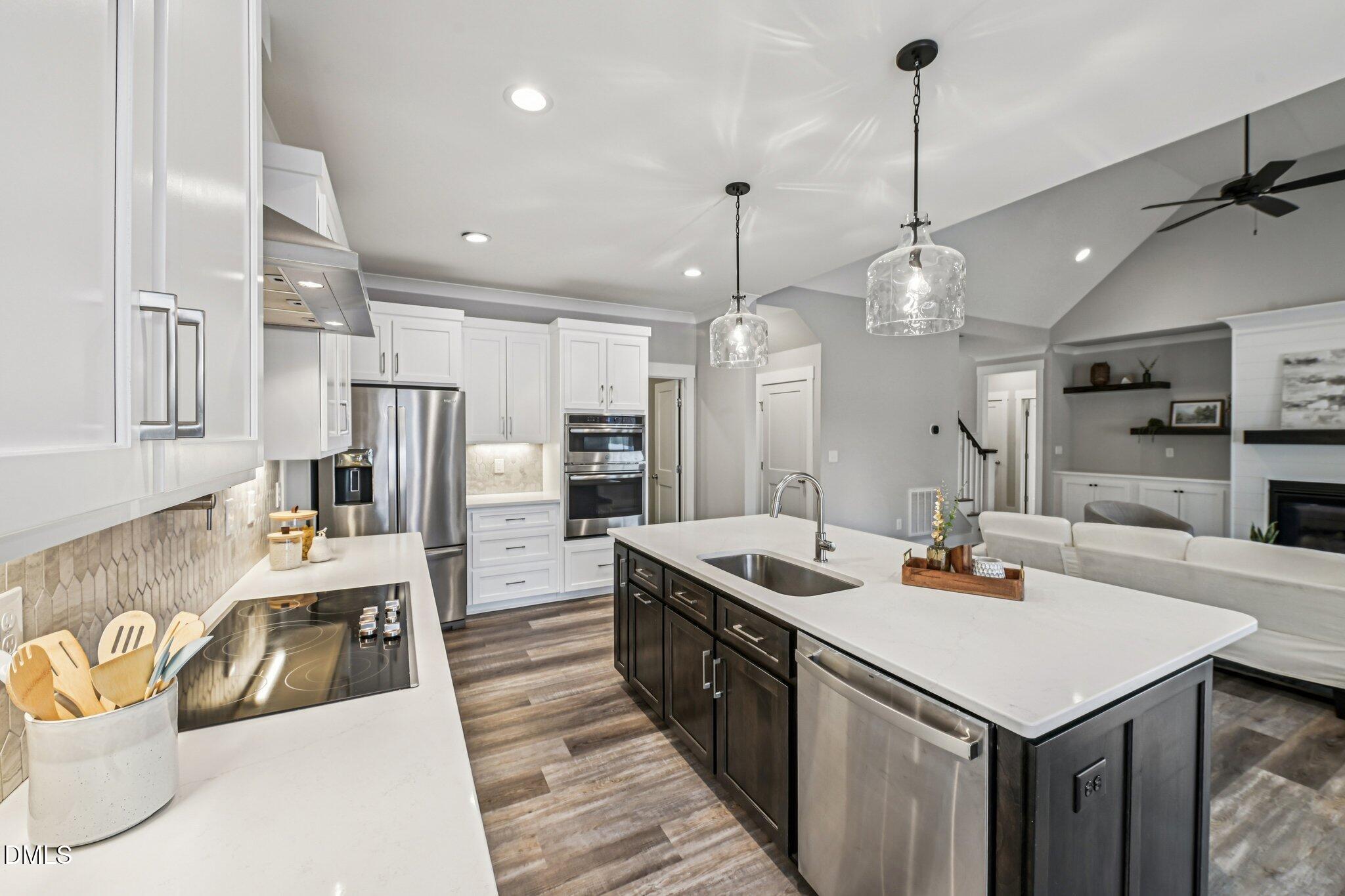 55 Dolores Court Willow Spring, NC 27592 - Photo 15 of 64 a kitchen with a stove a refrigerator a oven and a sink with wooden floor