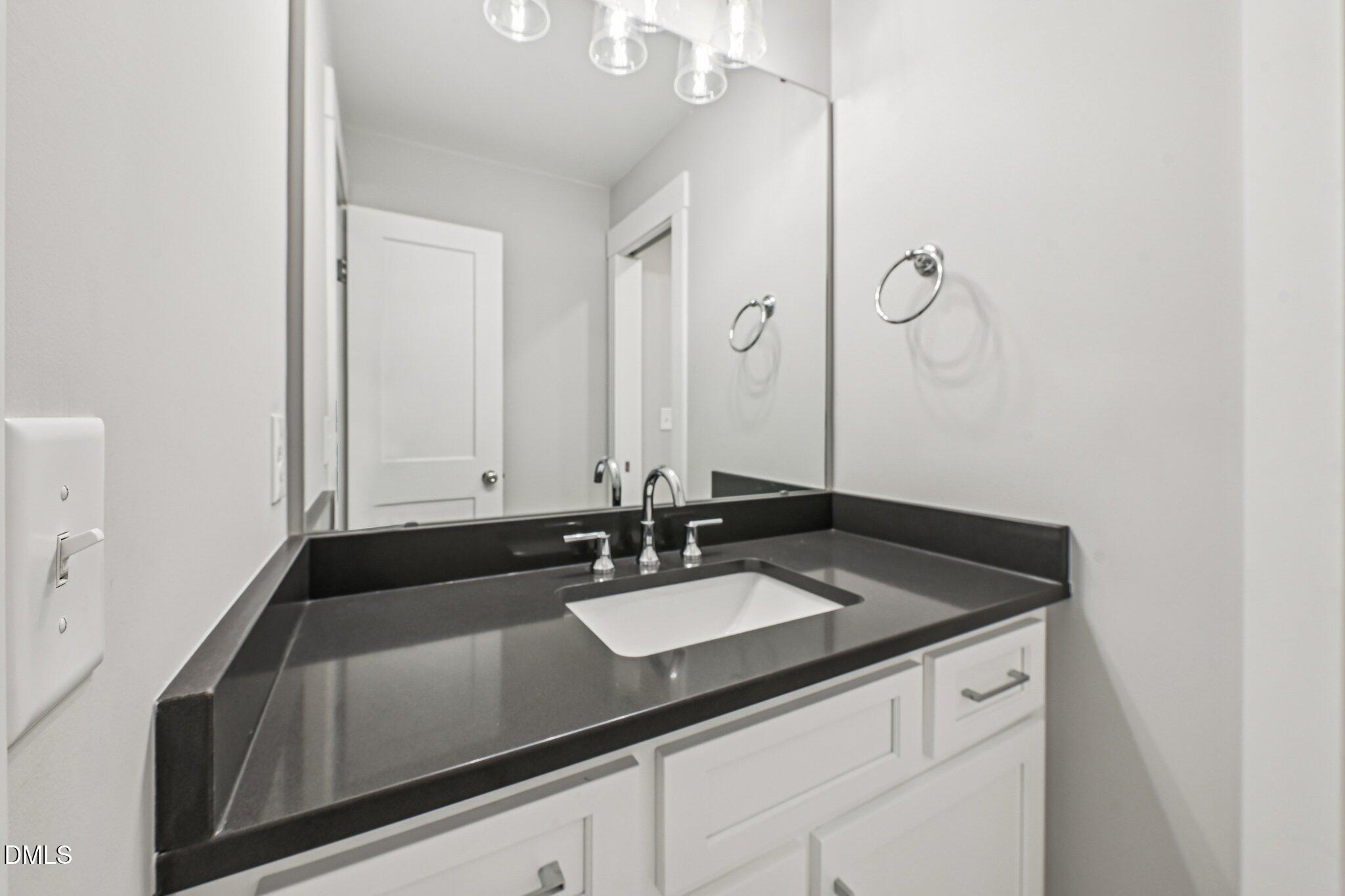 55 Dolores Court Willow Spring, NC 27592 - Photo 39 of 64 a bathroom with a sink and a mirror