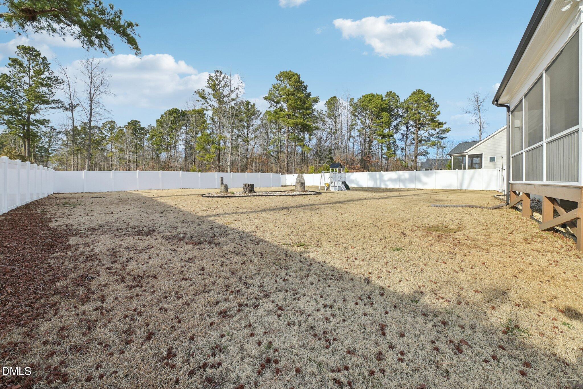 55 Dolores Court Willow Spring, NC 27592 - Photo 46 of 64 a view of a yard with a house and trees in the background