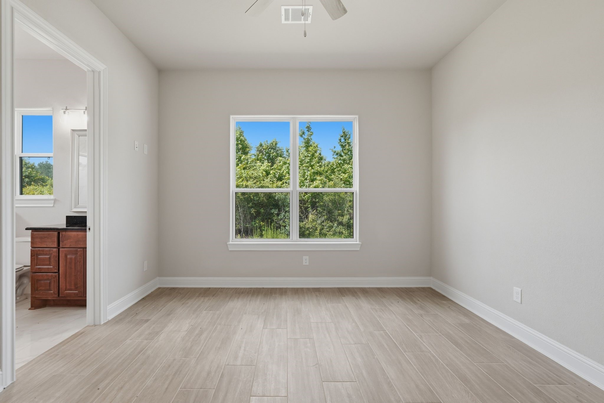 16081 Forest Mill Road Willis, TX 77378 - Photo 33 of 37 Thoughtfully designed for independent living, this spacious primary bedroom provides a tranquil setting with beautiful natural light and serene views.