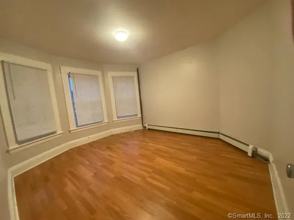 a view of an empty room and wooden floor