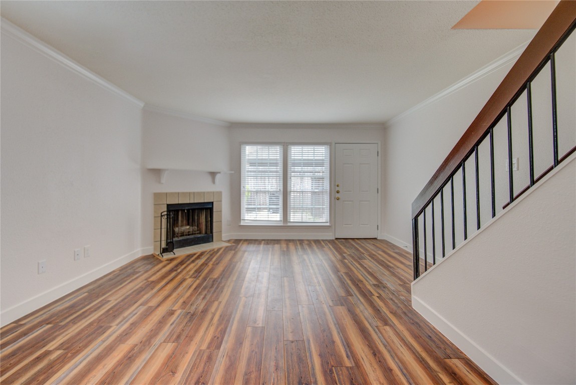 2002 Gentryside Drive, Unit 117 Houston, TX 77077 - Photo 11 of 31 an empty room with wooden floor fireplace and windows