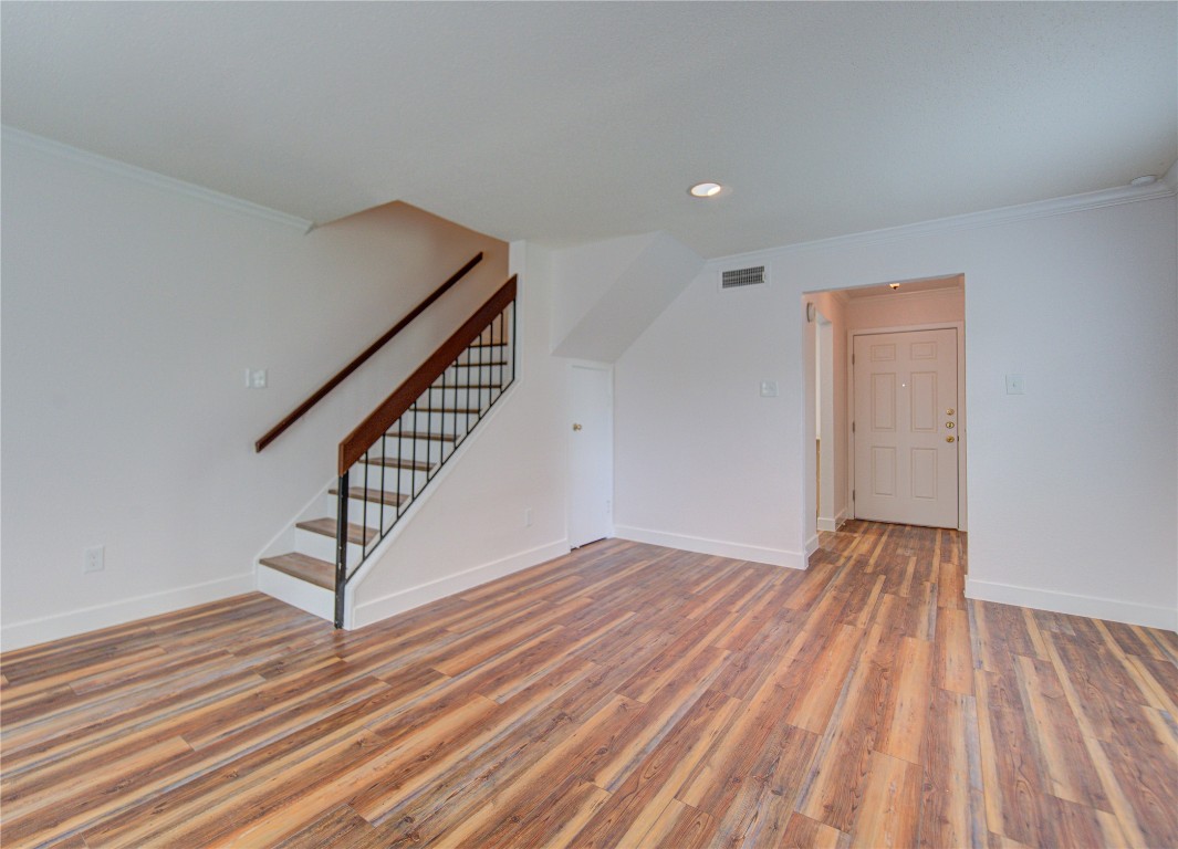 2002 Gentryside Drive, Unit 117 Houston, TX 77077 - Photo 12 of 31 a view of an empty room with wooden floor and stairs