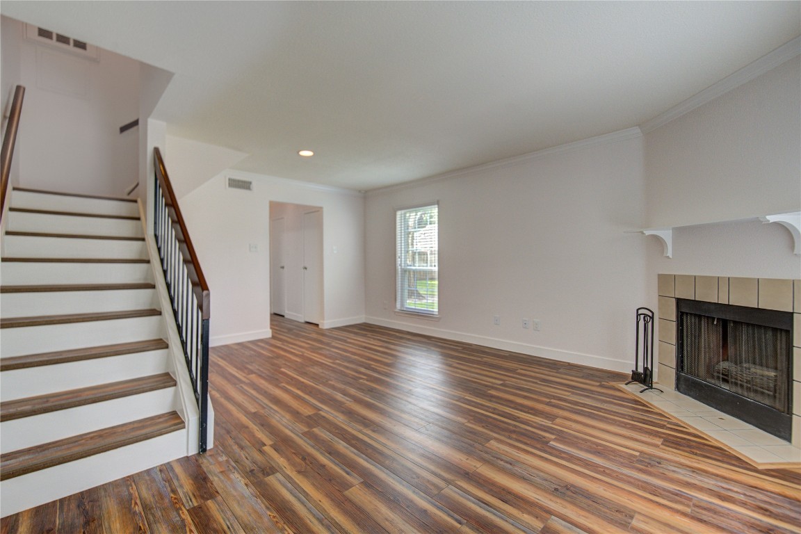 2002 Gentryside Drive, Unit 117 Houston, TX 77077 - Photo 13 of 31 a view of an empty room with wooden floor fireplace and a window