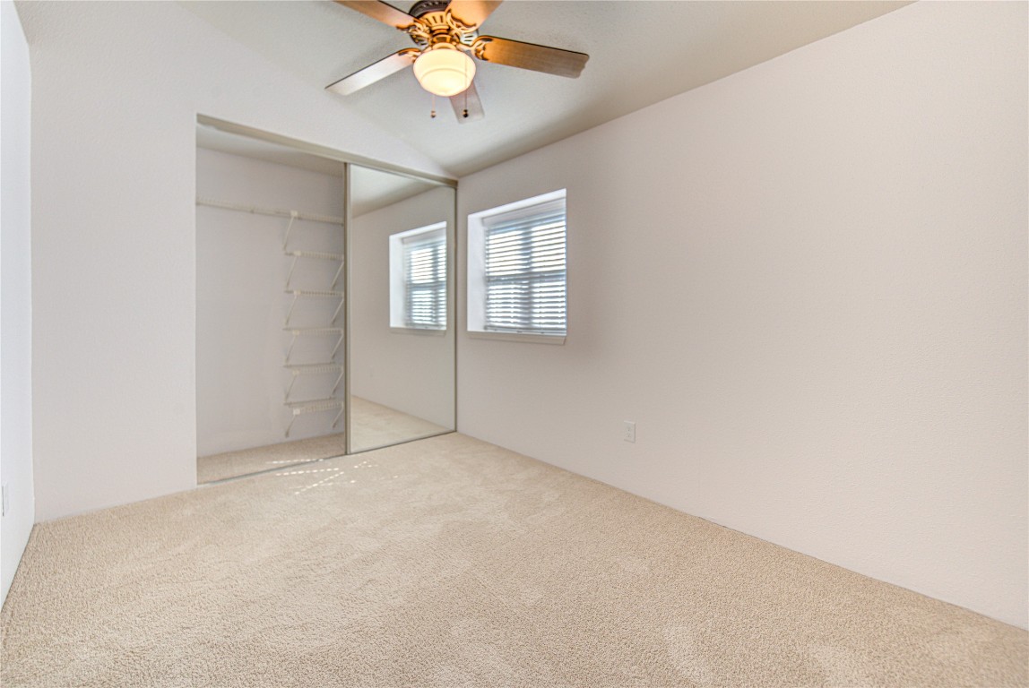 2002 Gentryside Drive, Unit 117 Houston, TX 77077 - Photo 17 of 31 an empty room with a chandelier fan and windows