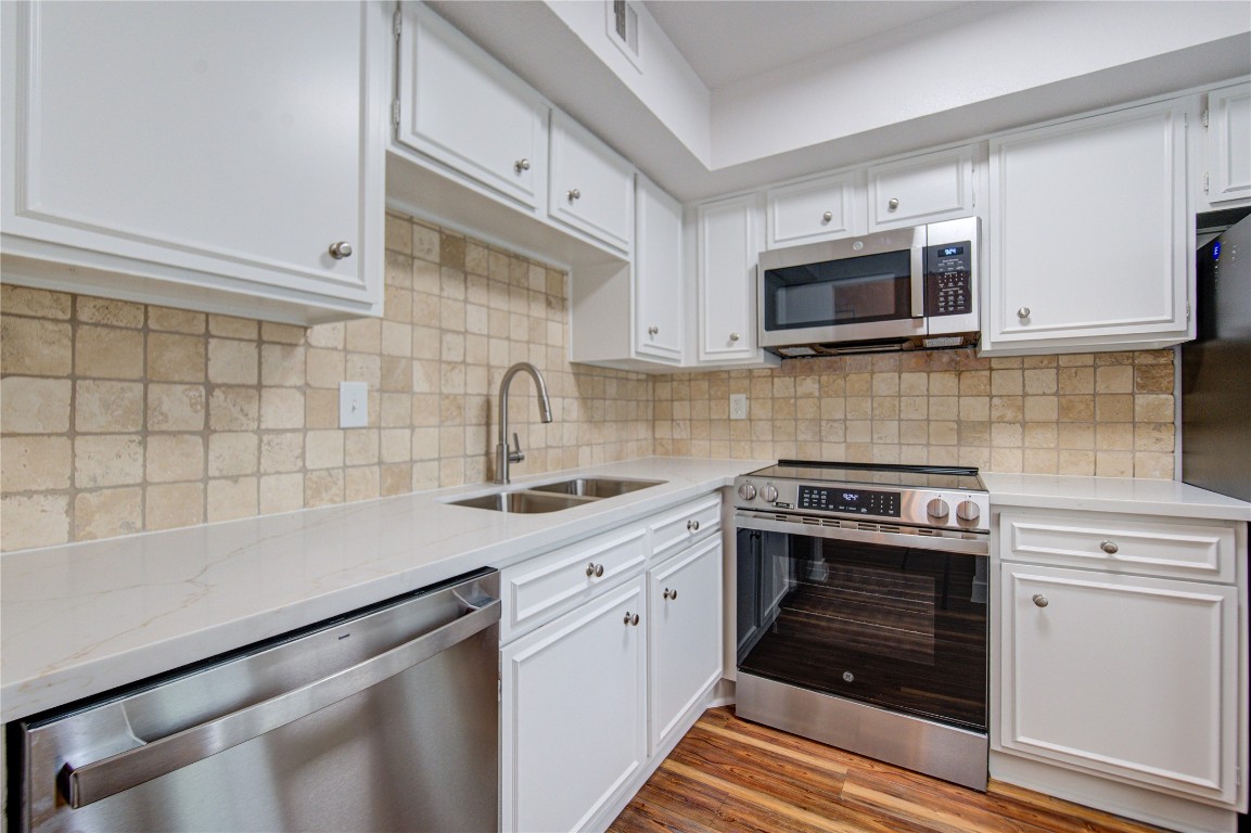 2002 Gentryside Drive, Unit 117 Houston, TX 77077 - Photo 5 of 31 a kitchen with white cabinets stainless steel appliances and sink