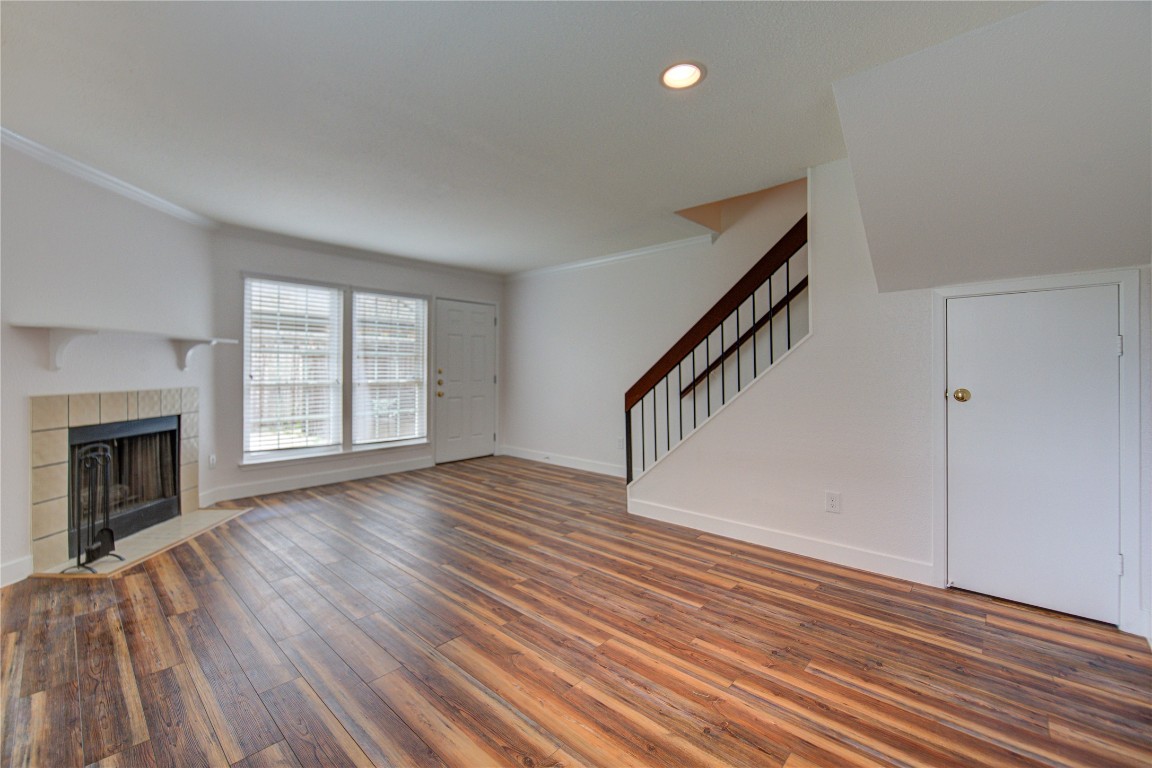 2002 Gentryside Drive, Unit 117 Houston, TX 77077 - Photo 9 of 31 a view of an empty room with wooden floor fireplace and a window