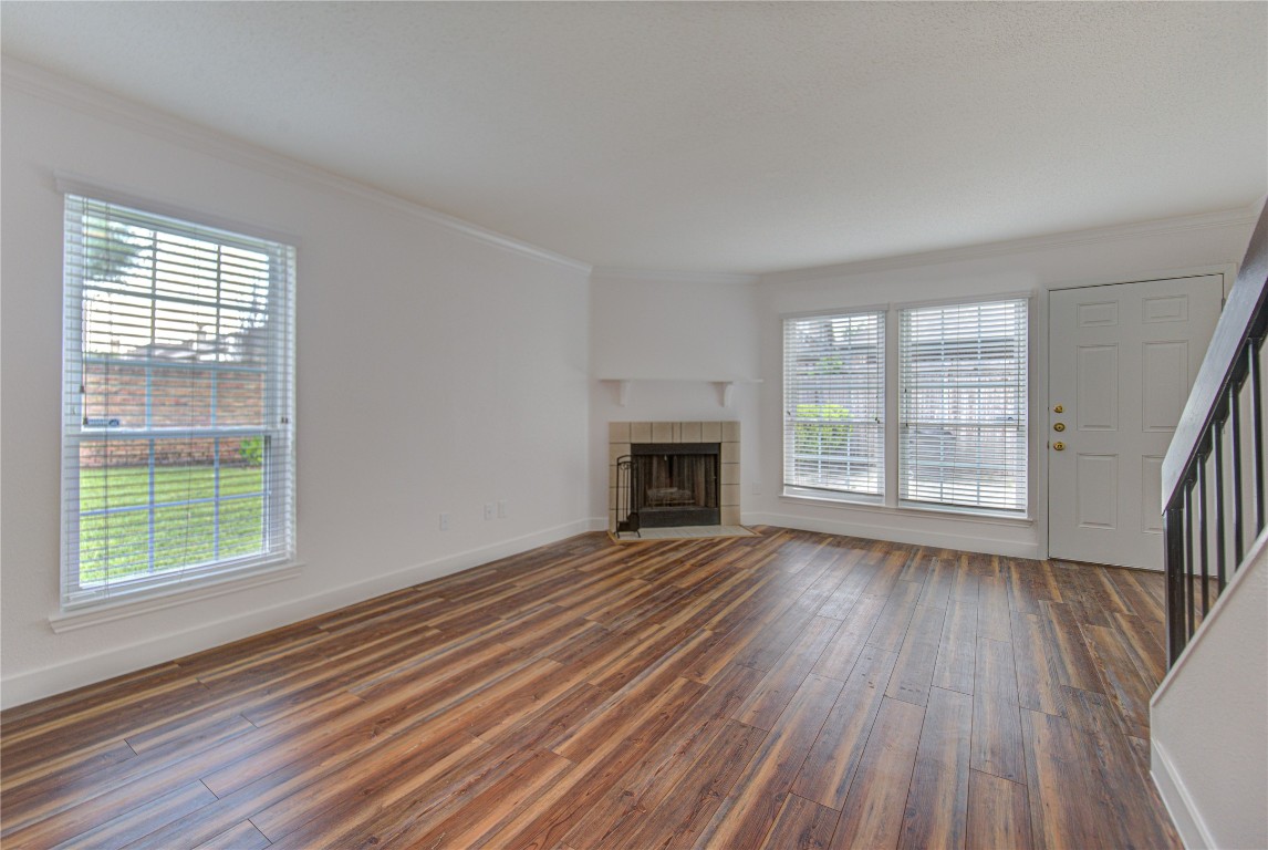 2002 Gentryside Drive, Unit 117 Houston, TX 77077 - Photo 10 of 31 a view of an empty room with wooden floor fireplace and a window