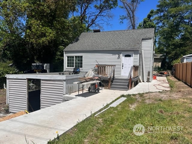 2644 Southwest 112th Street Seattle, WA 98146 - Photo 1 of 1 a view of house with yard outdoor seating and covered with trees in the background