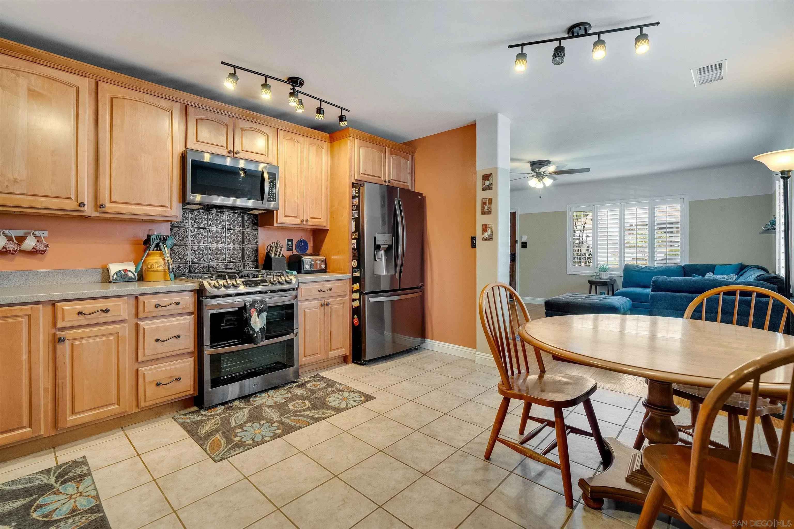 4516 Olive Avenue La Mesa, CA 91942 - Photo 11 of 48 a kitchen with stainless steel appliances a stove a sink dishwasher a dining table and chairs with wooden floor