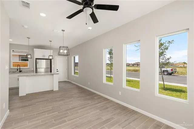 a view of empty room with wooden floor and window