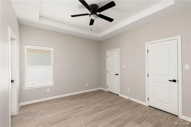 a view of a livingroom with a ceiling fan & hardwood floor