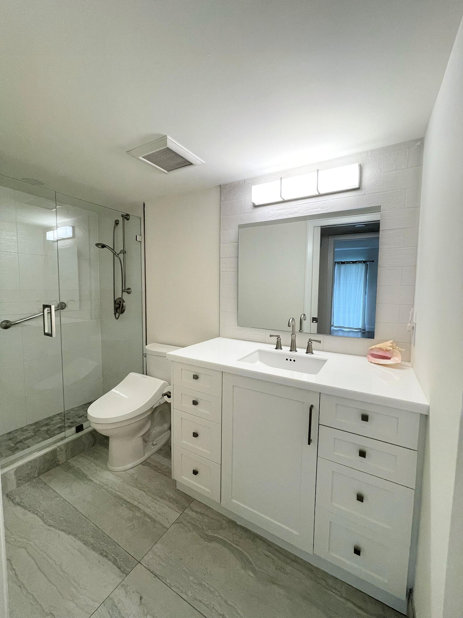 1030 Rexford B Boca Raton, FL 33434 - Photo 21 of 27 a bathroom with a toilet a sink a mirror and a shower