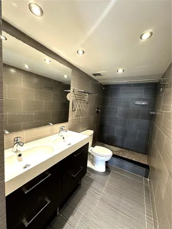 a bathroom with a double vanity sink toilet and a shower