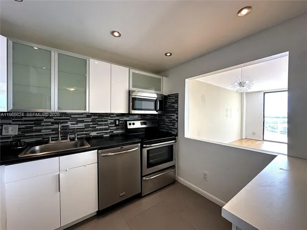 a view of a kitchen with stainless steel appliances granite countertop a stove and a sink