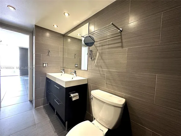a bathroom with a sink toilet vanity and shower
