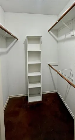 a view of walk in closet with empty racks