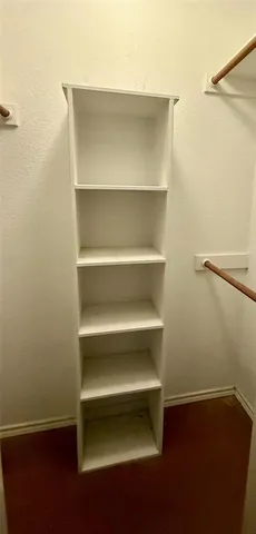 a view of walk in closet with empty racks