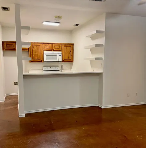 a kitchen with kitchen island a sink appliances and a counter top space