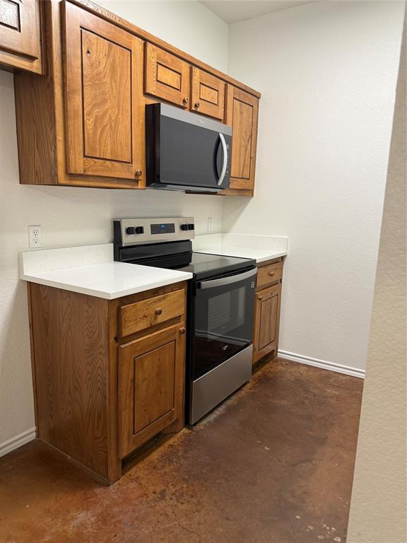 954 East 3rd Street Weatherford, TX 76086 - Photo 4 of 17 a kitchen with stainless steel appliances granite countertop a stove microwave and sink