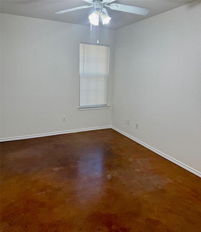 954 East 3rd Street Weatherford, TX 76086 - Photo 8 of 17 an empty room with a chandelier fan and windows