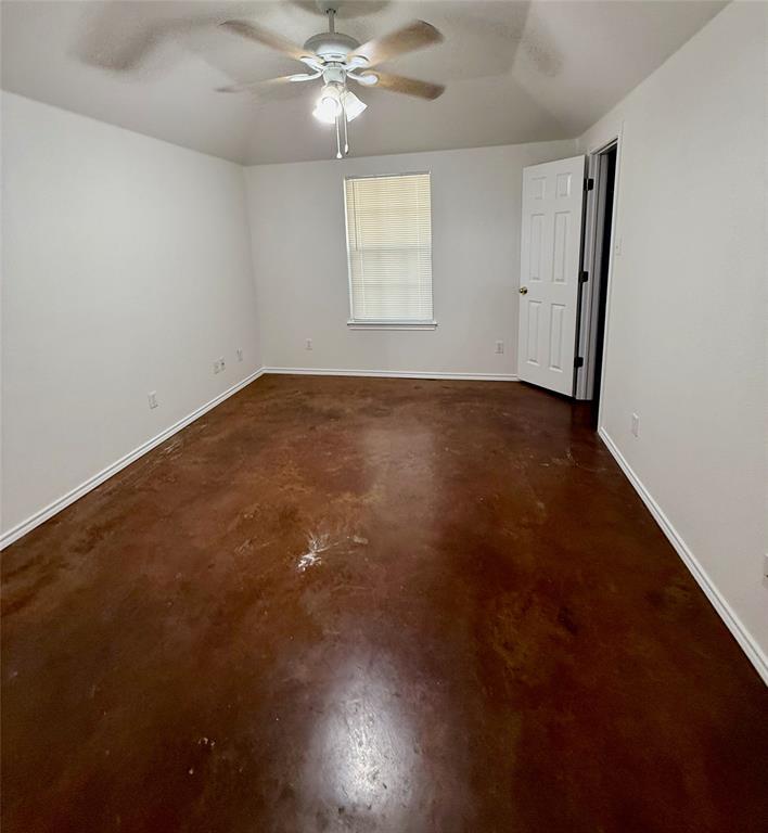 954 East 3rd Street Weatherford, TX 76086 - Photo 9 of 17 an empty room with a chandelier fan and windows