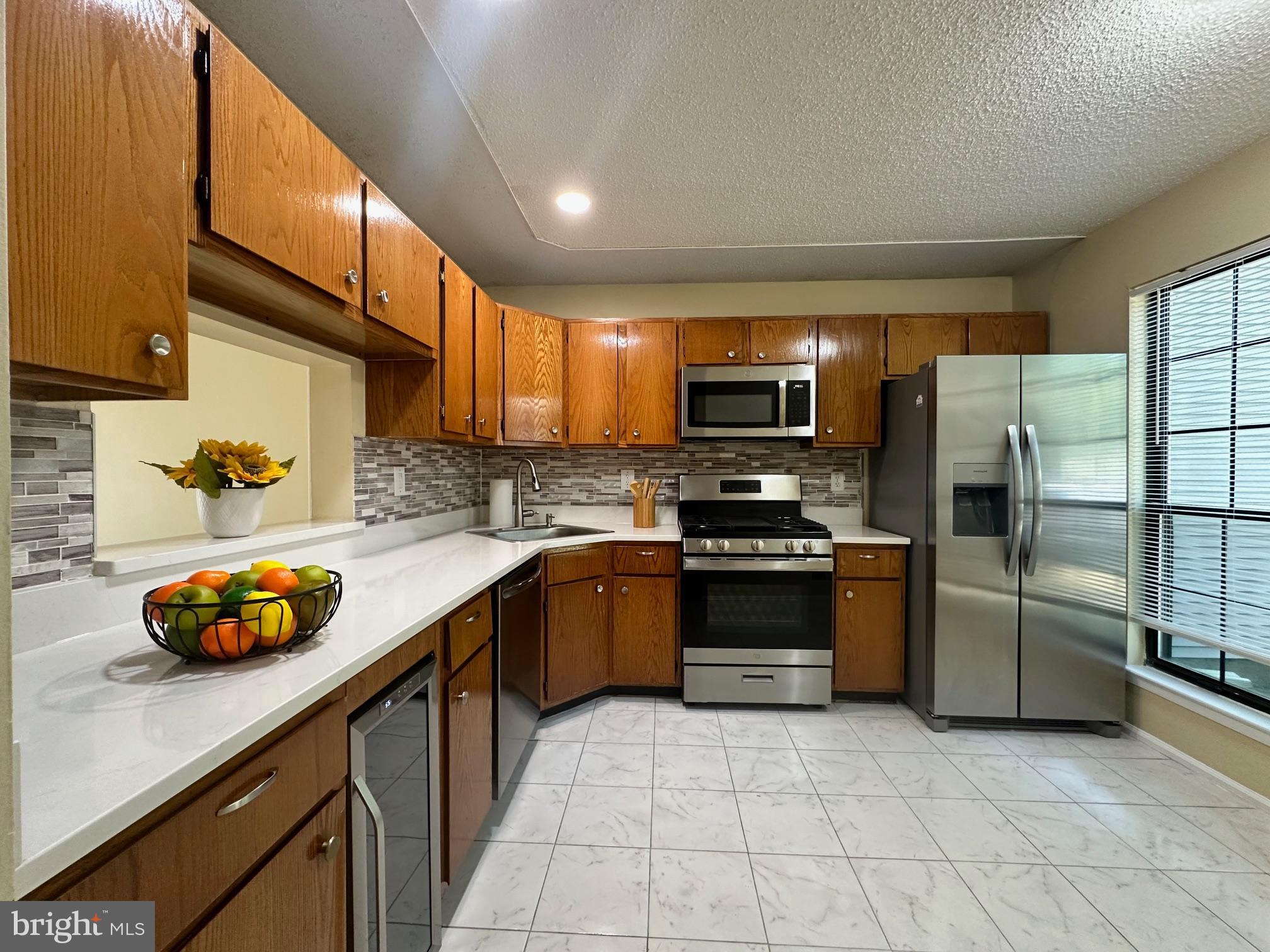 6 Wosniak Court Lawrence Township, NJ 08648 - Photo 3 of 20 a kitchen with stainless steel appliances a stove a sink a refrigerator and a microwave