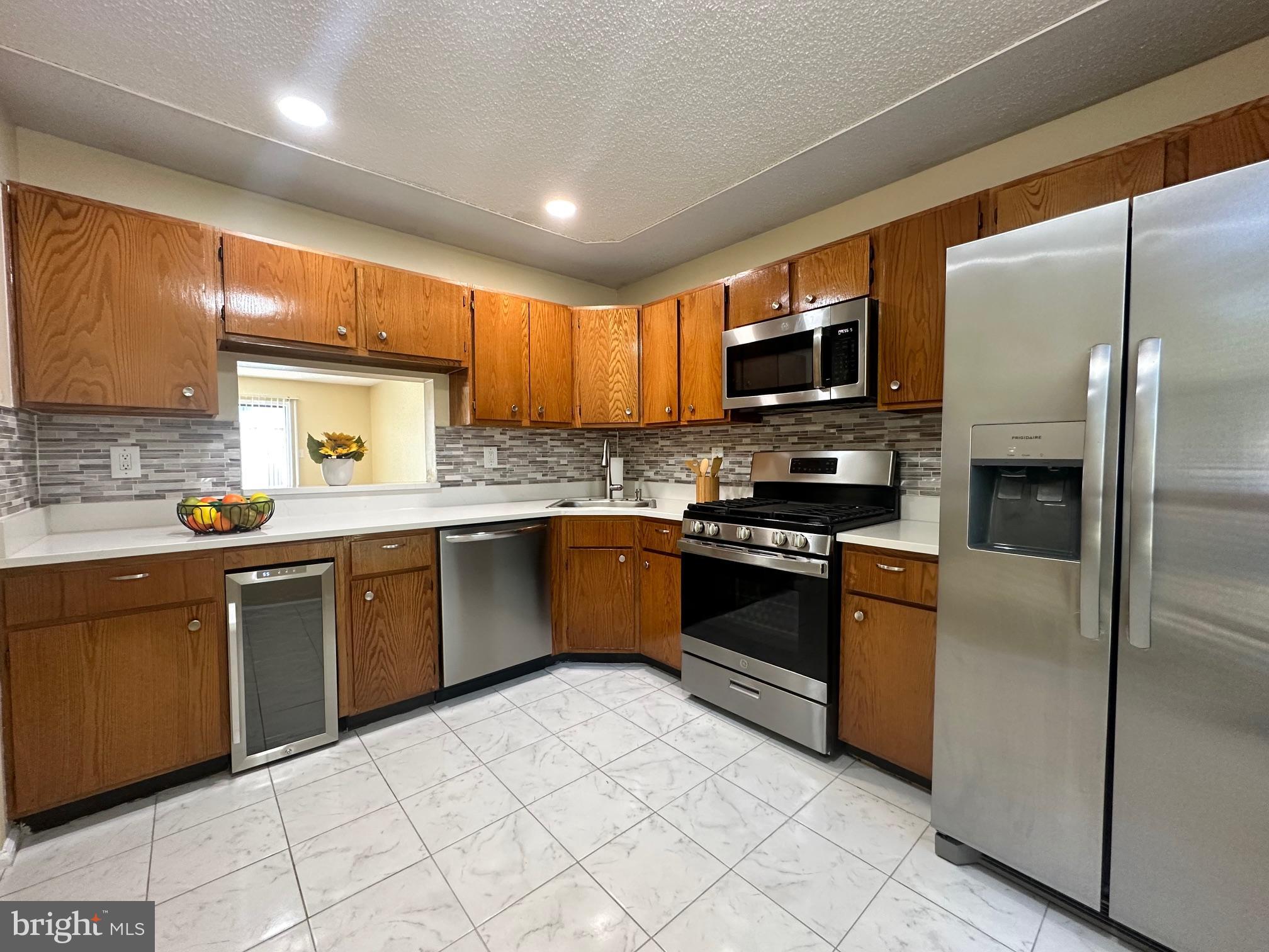 6 Wosniak Court Lawrence Township, NJ 08648 - Photo 4 of 20 a kitchen with stainless steel appliances granite countertop a refrigerator a sink a stove top oven and a refrigerator