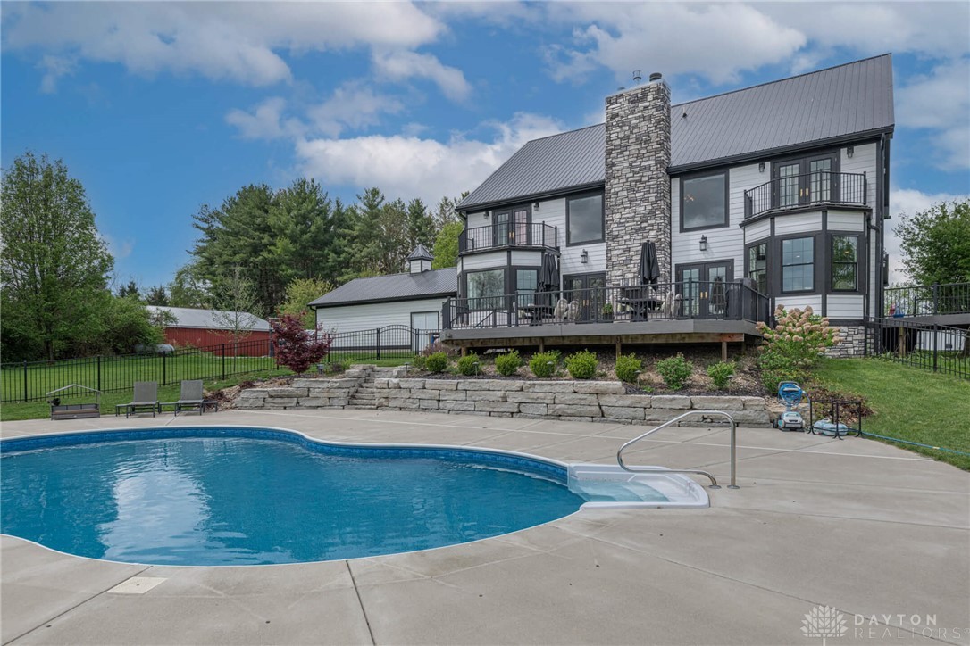 9586 Ferry Road Waynesville, OH 45068 - Photo 27 of 40 This modern home offers expansive outdoor living with a private pool, spacious deck, and mature landscaping.