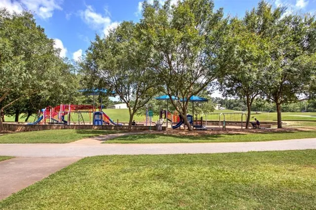 a view of a playground ground and trees