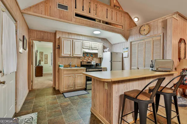 a kitchen with a table chairs refrigerator and cabinets