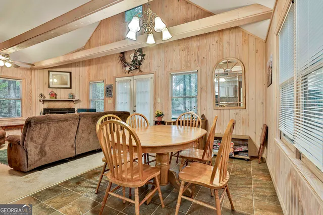 a dining room with furniture a chandelier and wooden floor