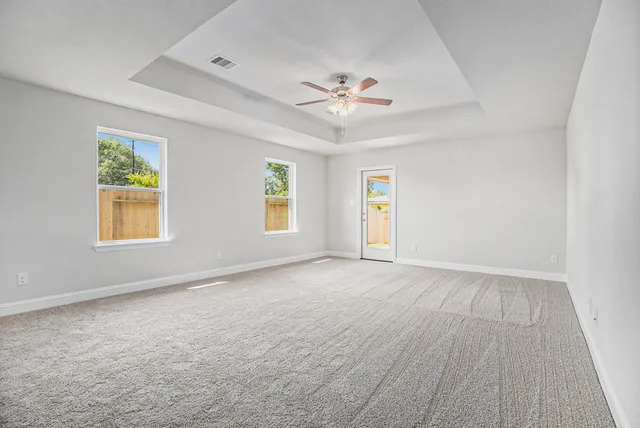 a view of an empty room with a window and closet area