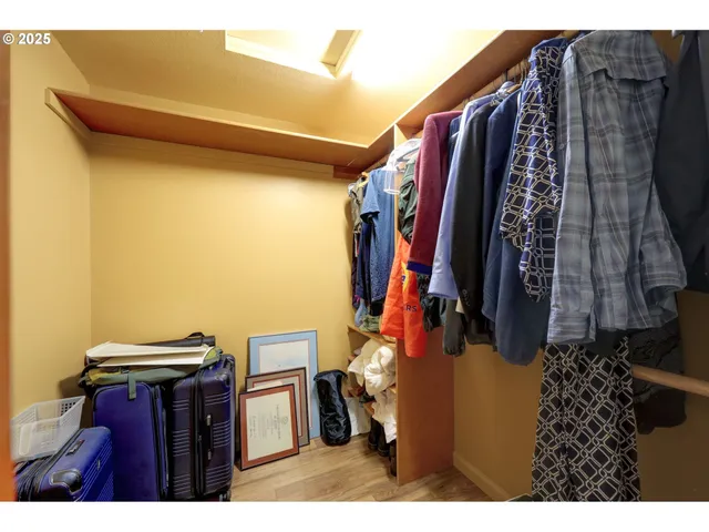 a view of walk in closet with clothes and shoes